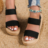 Sandale Compensée Femme Durable avec Lanières portée par une femme sur du sable avec des bracelets de cheville et un jean bleu déchiré