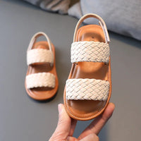 Sandale Fille avec Lanières Tressées Beige, sur un fond gris.