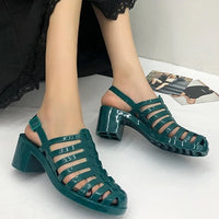 Sandale Meduse Verte avec Fermeture à Boucle, avec talon carré portée par une femme.