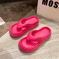 Sandale Plateforme Femme Design Style Tong posé sur un sol effet bois gris avec un tapis à gauche