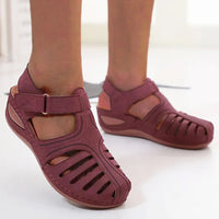 Sandale Scratch Femme à Talon Compensé avec Boucle sur les pieds d'une personne sur fond blanc