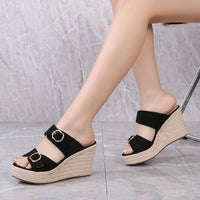 Sandale Talon Compensée Style Pantoufle Noire, portée par une femme.