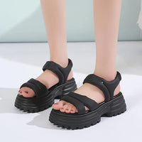 Sandale Talon Plateforme avec Fermeture Élastique, de couleur noires, portées par une femme.