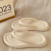 Sandale Tong Femme Originale et Souple posée sur un tissu blanc avec un calendrier à gauche