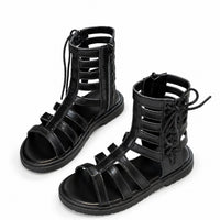 Sandales montantes noires pour fille avec lanières ajourées, lacets et fermeture éclair, au design moderne et tendance.