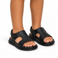 Sandales noires souples pour garçon, style décontracté, avec larges lanières croisées et semelle antidérapante.
