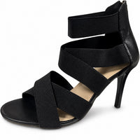 Sandale gladiateur noire avec talon haut et lanières noires. La chaussure présente plusieurs lanières elastiques croisées sur le pied, une semelle plate noire, et un talon stiletto noir. Elle est présentée sur fond blanc.