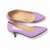 Sandale talon femme 5-7 cm violette de style escarpin. La chaussure présente un talon fin violette d'environ 5-7 cm de hauteur, un bout fermé pointu très élancé, une matière laquée brillante violette-mauve pastel, une semelle plate beige-taupe contrastante, doublure intérieure beige, design très épuré et sophistiqué inspiré de l'escarpin. Présentées sur fond blanc.