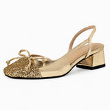 Sandale Dorée à Talon Bas Style Ballerine avec finition métallisée, bout arrondi scintillant orné d’un nœud, bride arrière et talon carré bas pour un style chic et élégant.