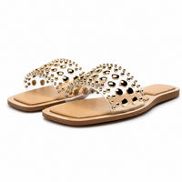 Sandale Femme Cloutée Beige et Plate avec large bride ornée de clous et rivets dorés, bout ouvert, semelle plate confortable et design élégant pour un style estival tendance.