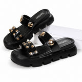 Sandale Femme Cloutée avec Semelle Épaisse noire avec doubles brides ornées de clous dorés, bout ouvert, semelle épaisse crantée et design moderne pour un style tendance et confortable.