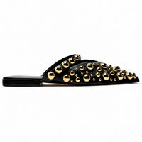 Sandale Femme Cloutée et Pointue avec Rivets Dorés noire avec empeigne ornée de rivets dorés de différentes tailles, bout pointu et semelle plate pour un style chic et tendance.