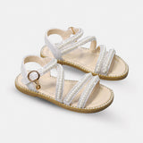 Sandale Fille avec Lanières Blanches et Perles Brillantes avec fines brides ornées de perles et strass, bride à la cheville réglable, semelle plate confortable et style élégant pour les cérémonies et occasions spéciales.