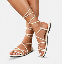 Sandale Gladiator Beige avec Fermeture à Lacets, à fines lanières croisées, lacets à enrouler autour de la jambe, semelle plate et design élégant