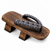 Sandale Japonaise Style Tong Traditionnelle en bois foncé avec semelle surélevée, lanières en tissu bleu à motifs japonais et design traditionnel inspiré des geta.