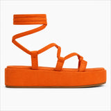 Sandale à Lacet Design avec Semelle Épaisse orange, lanières fines, lacets à enrouler autour de la cheville, plateforme épaisse et design moderne.