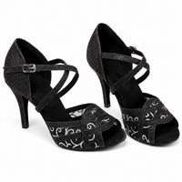 Sandale Talon Femme 10–13 cm Noire et Brillante avec brides croisées scintillantes, motifs argentés décoratifs, bout ouvert, bride réglable à la cheville et talon fin élégant.
