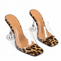 Sandale Talon Transparent avec Imprimé Léopard avec bride transparente, bout carré à motif léopard, talon géométrique transparent et design élégant pour les soirées et occasions spéciales.
