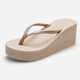 Sandale Tong Femme Moderne avec Semelle Compensée, bride entre-doigts dorée métallisée, plateforme compensée beige et design élégant.