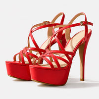 Sandales à talons hauts plateforme avec brides cheville rouges. La chaussure présente un talon très fin et très haut rouge d'environ 10-12 cm avec finition beige-doré contrastante, une semelle plateforme ultra-épaisse rouge laqué brillant avec finition beige-doré contrastante, plusieurs lanières croisées en cuir laqué rouge brillant qui s'entrecroisent sur le pied, une bride de cheville réglable avec boucle carrée dorée, doublure intérieure beige contrastante, design très spectaculaire, sexy et luxueux. Pré