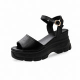 Sandales Plateformes Avec Fermeture À Boucle noires avec large bride avant, bride réglable à la cheville, semelle plateforme épaisse et crantée, et design moderne pour un style urbain et confortable.