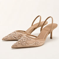 Sandales à talons beiges en maille transparente, ornées de broderies florales et de perles blanches, avec brides arrière élégantes.